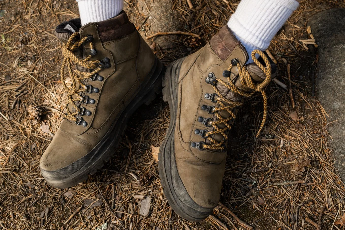 Wanderschuhe mit Socken auf einem Waldweg.
