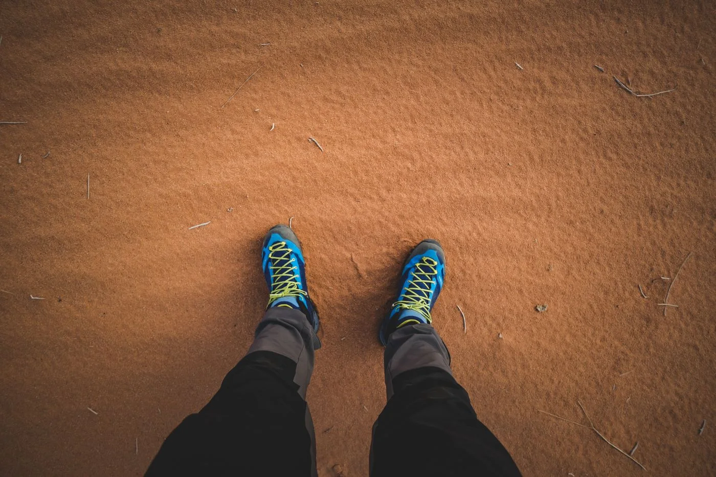 Textil-Wanderschuhe auf sandigem Boden.