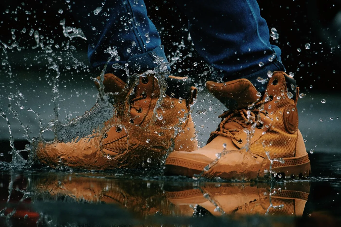 Wanderschuhe beim Schritt durch eine Pfütze.