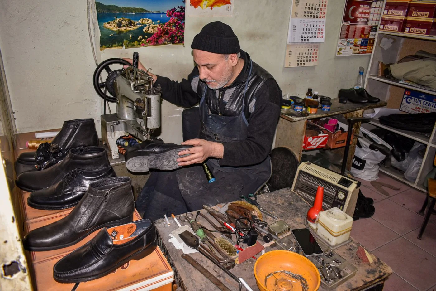 Ein Schuhmacher arbeitet an einer Sohle.