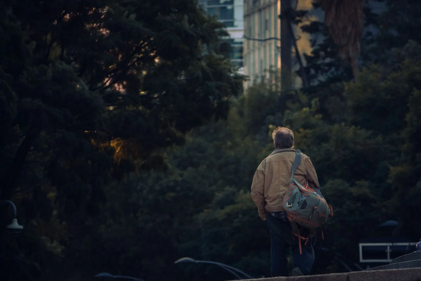 Eine Person mit Rucksack auf einem Stadtweg.