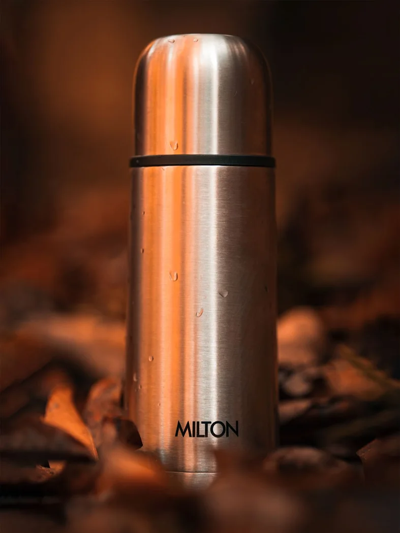 Eine Isolierflasche im Herbstlaub.
