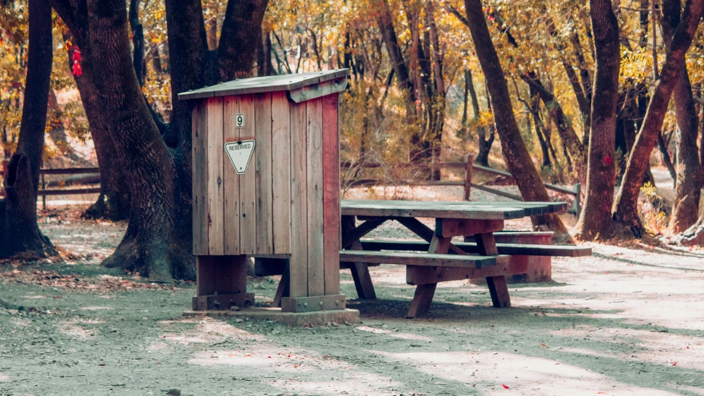 A picnic table beside a forest path.