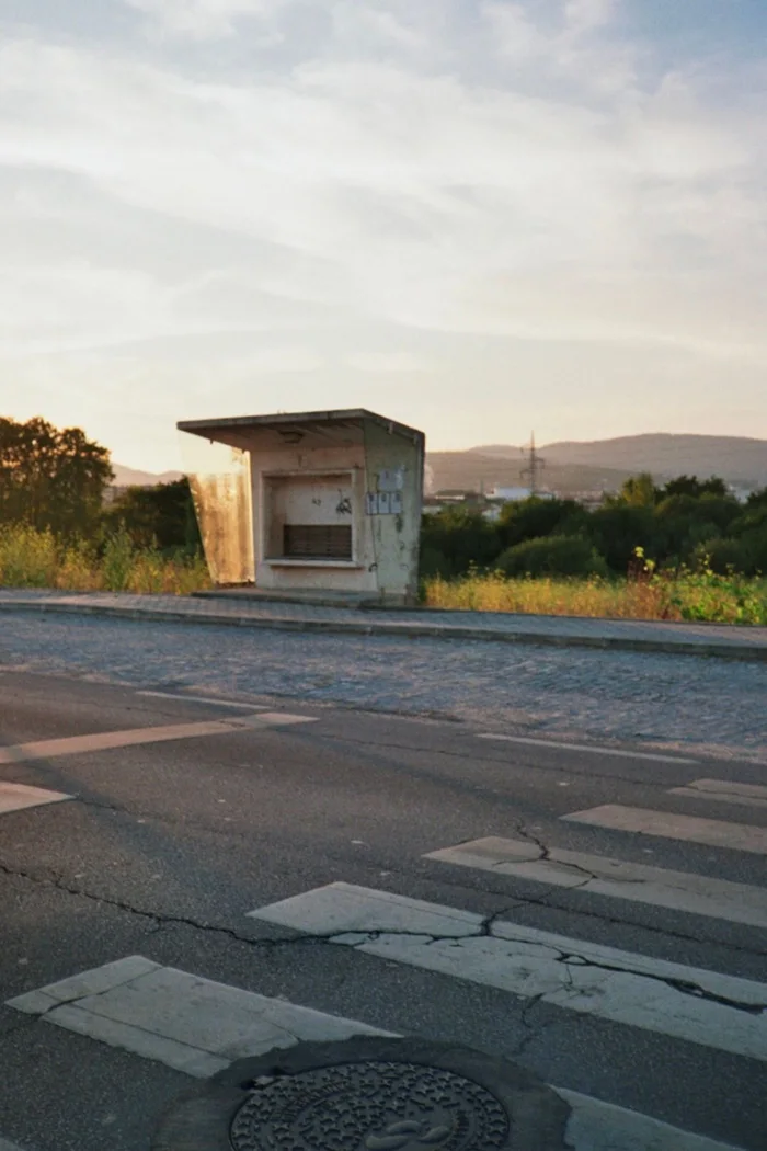 A bus shelter beside a country road.